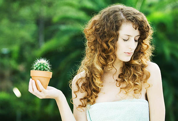 Chica sosteniendo una olla de cactus